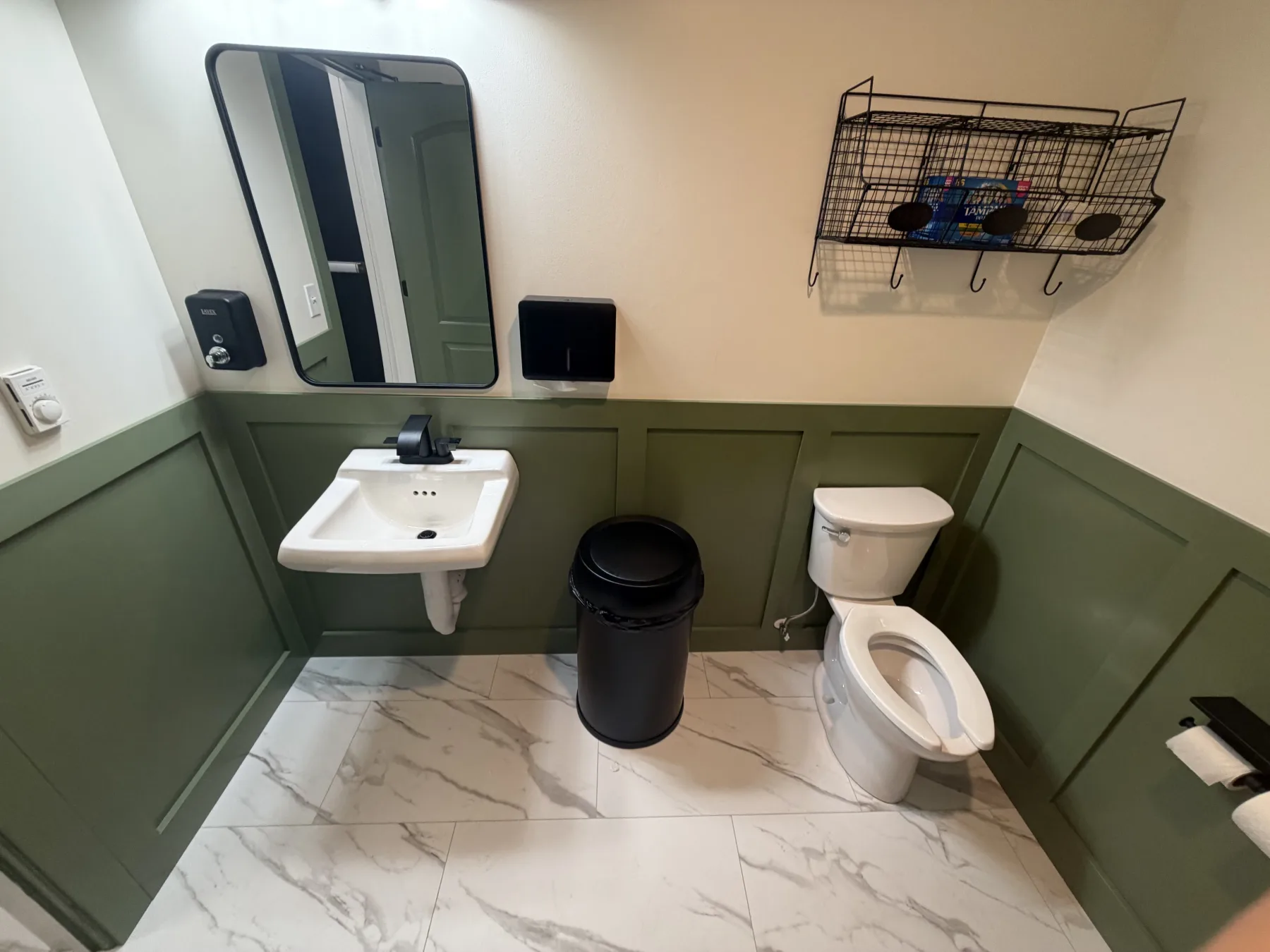 toilet, sink, mirror, trash can, toilet paper, basket, wall, floor
