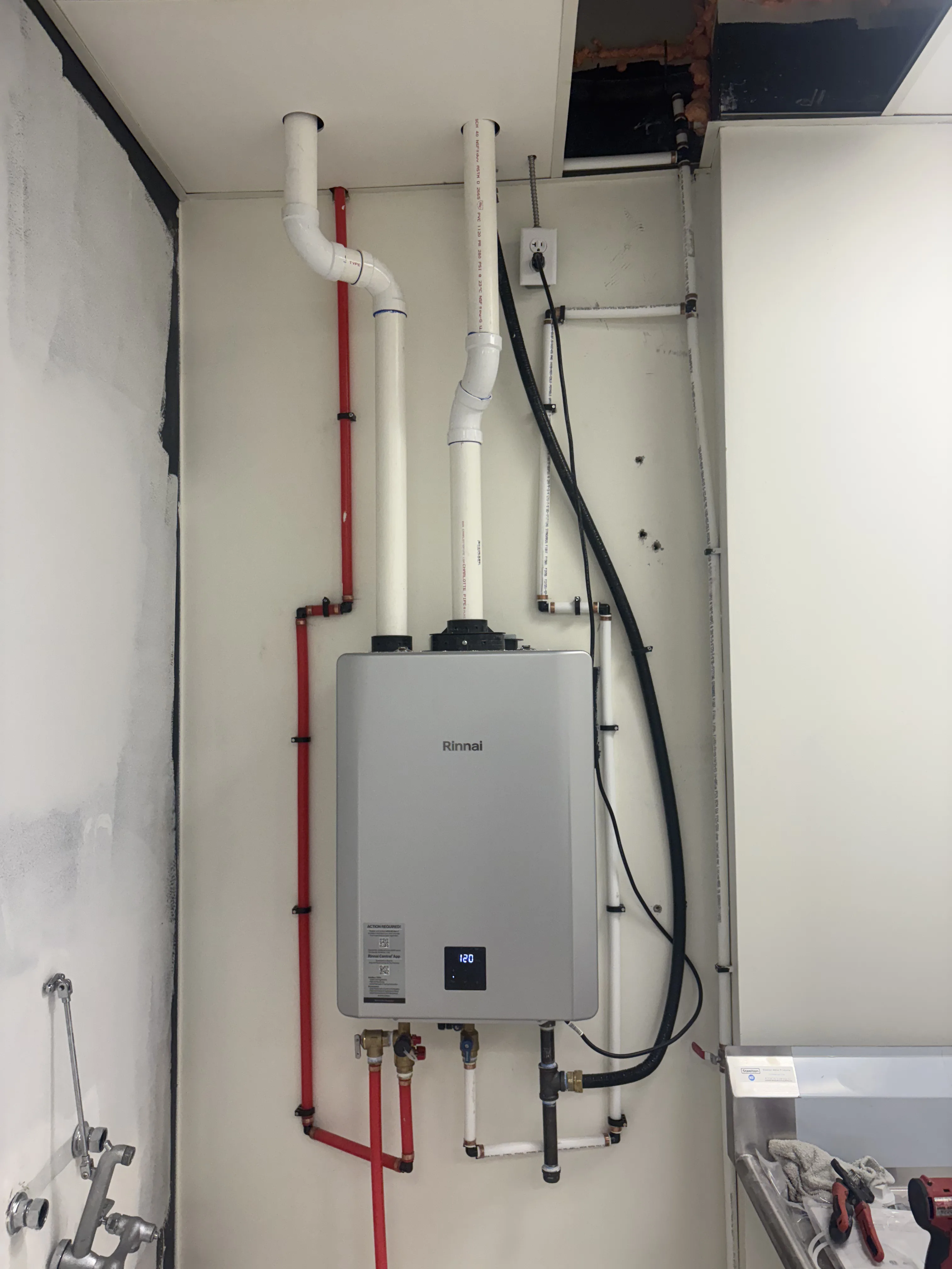 rinnai, tankless water heater, pipes, electrical outlet, screws, screwdriver, wrench